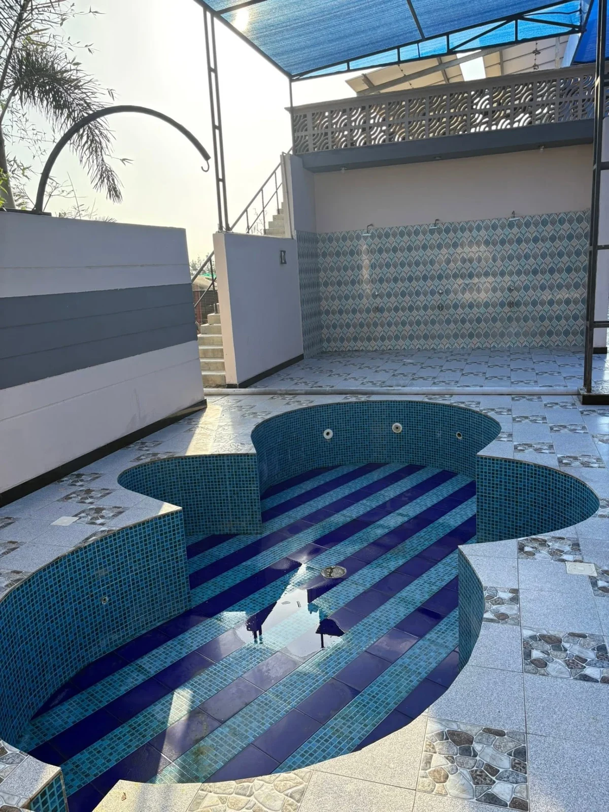Round mosaic kids pool beside the main pool